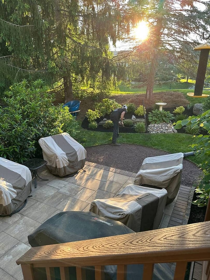 a patio with chairs and landscape design in back