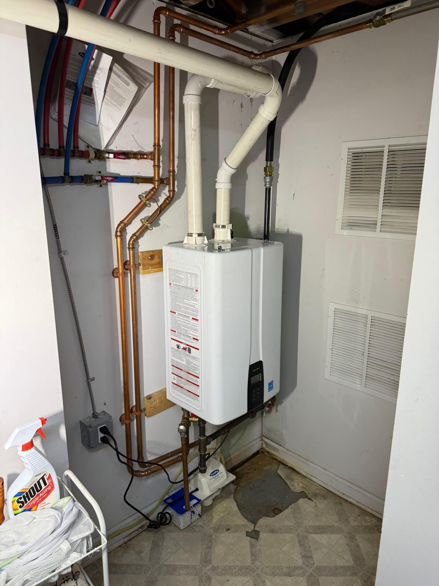 a white tankless water heater with pipes after installation a white tankless water heater with pipes after installation